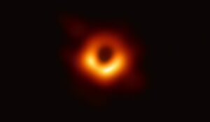 The first image of a black hole's shadow, M87*, a glowing orange ring around darkness.